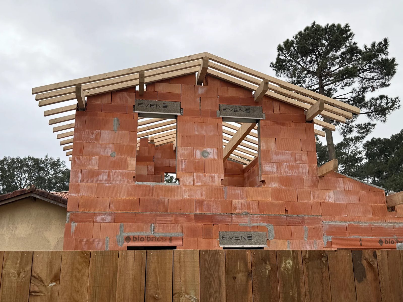 Charpente posée sur les murs en briques d'une maison en construction