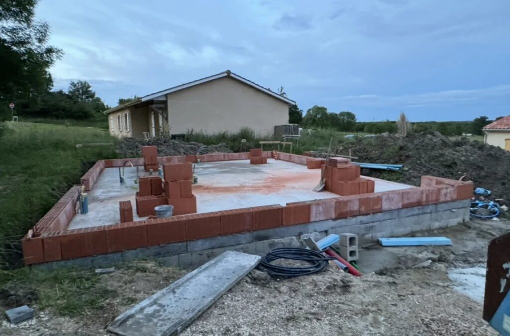 Élévation des murs en briques d'une maison neuve sur sa dalle